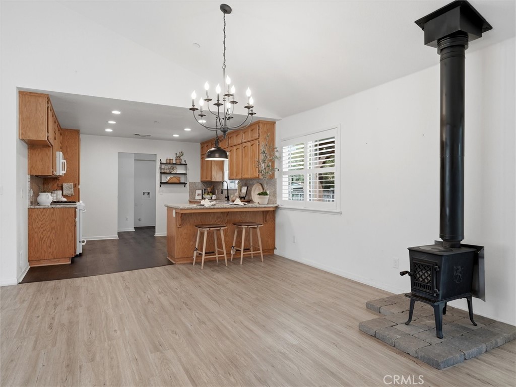 Open kitchen and living area with a breakfast bar and freestanding wood stove.