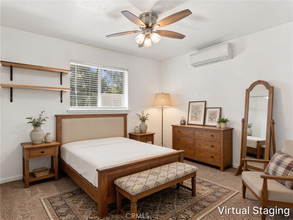 Bedroom with a wooden bed, matching furniture, patterned rug, and ceiling fan.