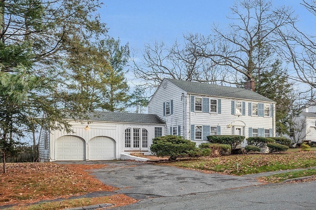 White two-story colonial home with blue shutters and an attached two-car garage.