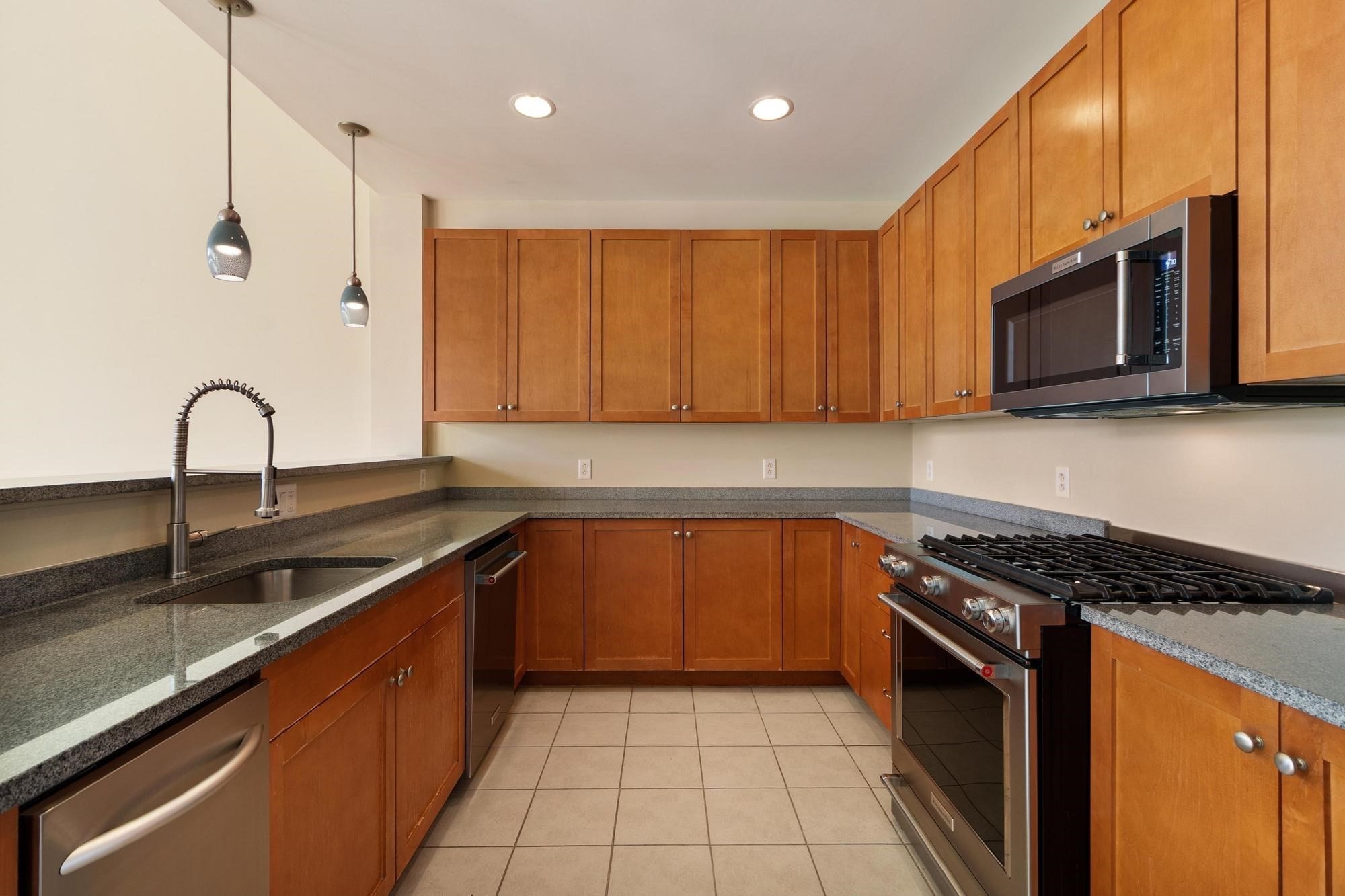 Kitchen with wood cabinets, granite counters, and stainless steel appliances.