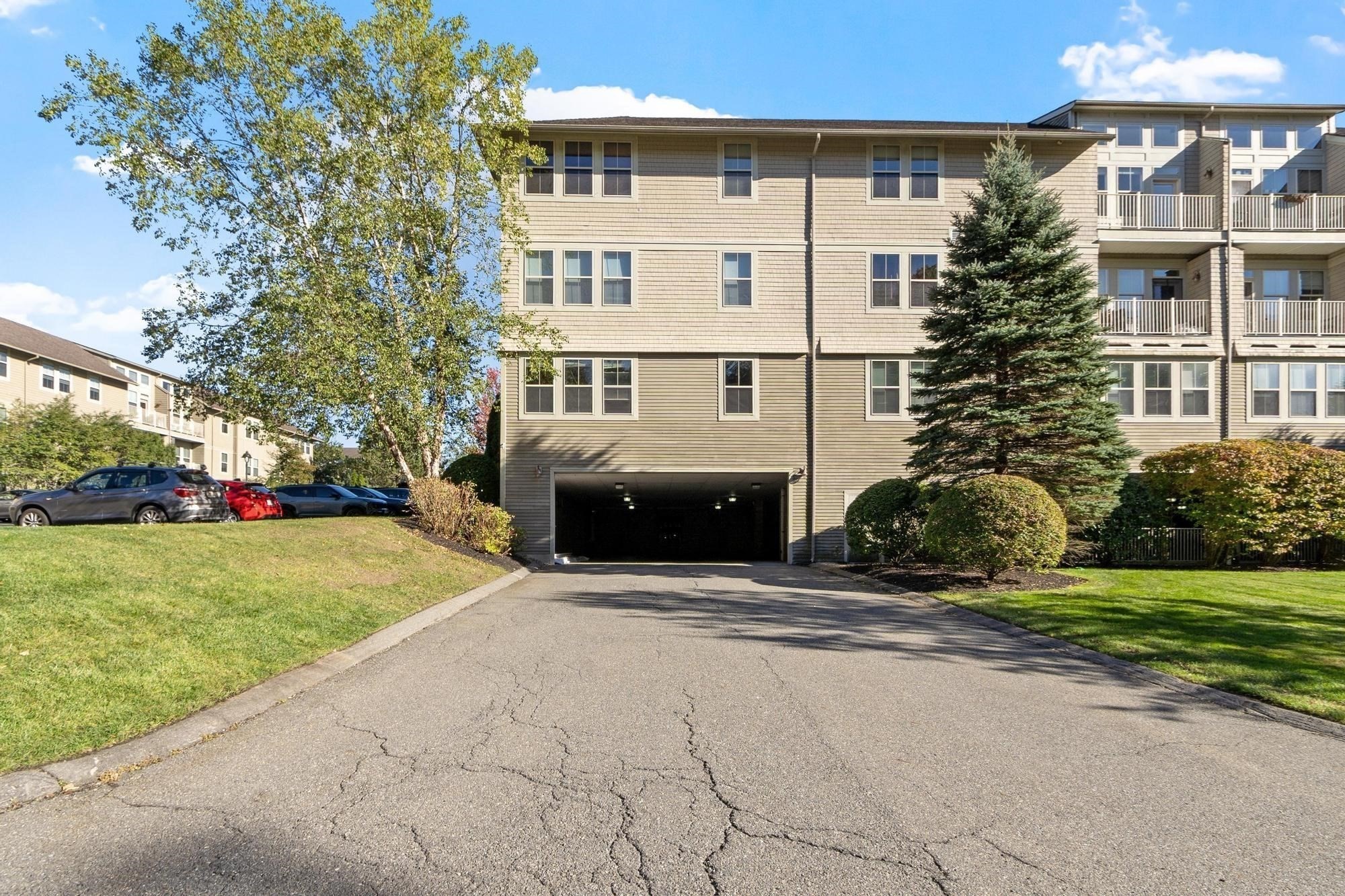 Multi-story residential building with balconies and a covered garage entrance