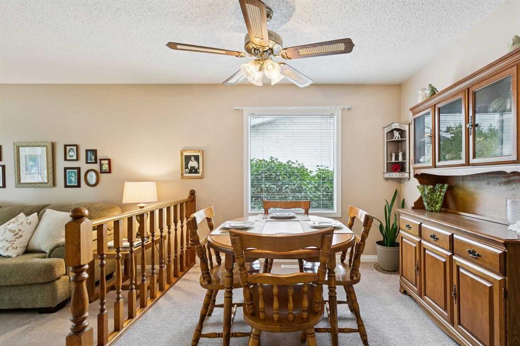 Dining room with a round wooden table, built-in cabinetry, and a ceiling fan.