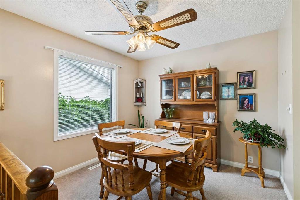 Dining room with a round wooden table, matching chairs, and a glass-front china cabinet.