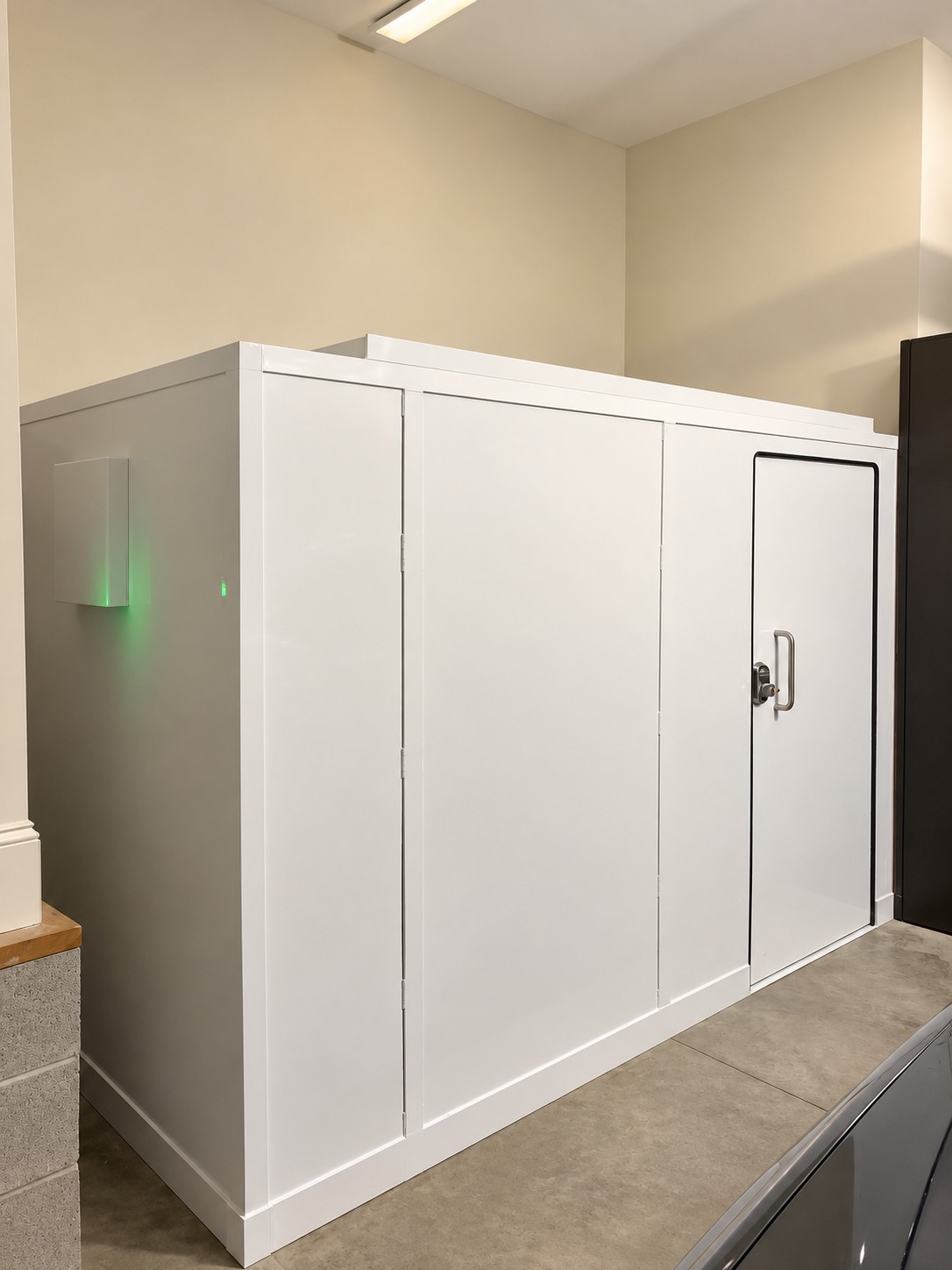 Large white enclosure with a small access door and glowing green indicator light
