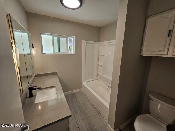 Bathroom with a long vanity, window, bathtub and shower, and gray tile floor.