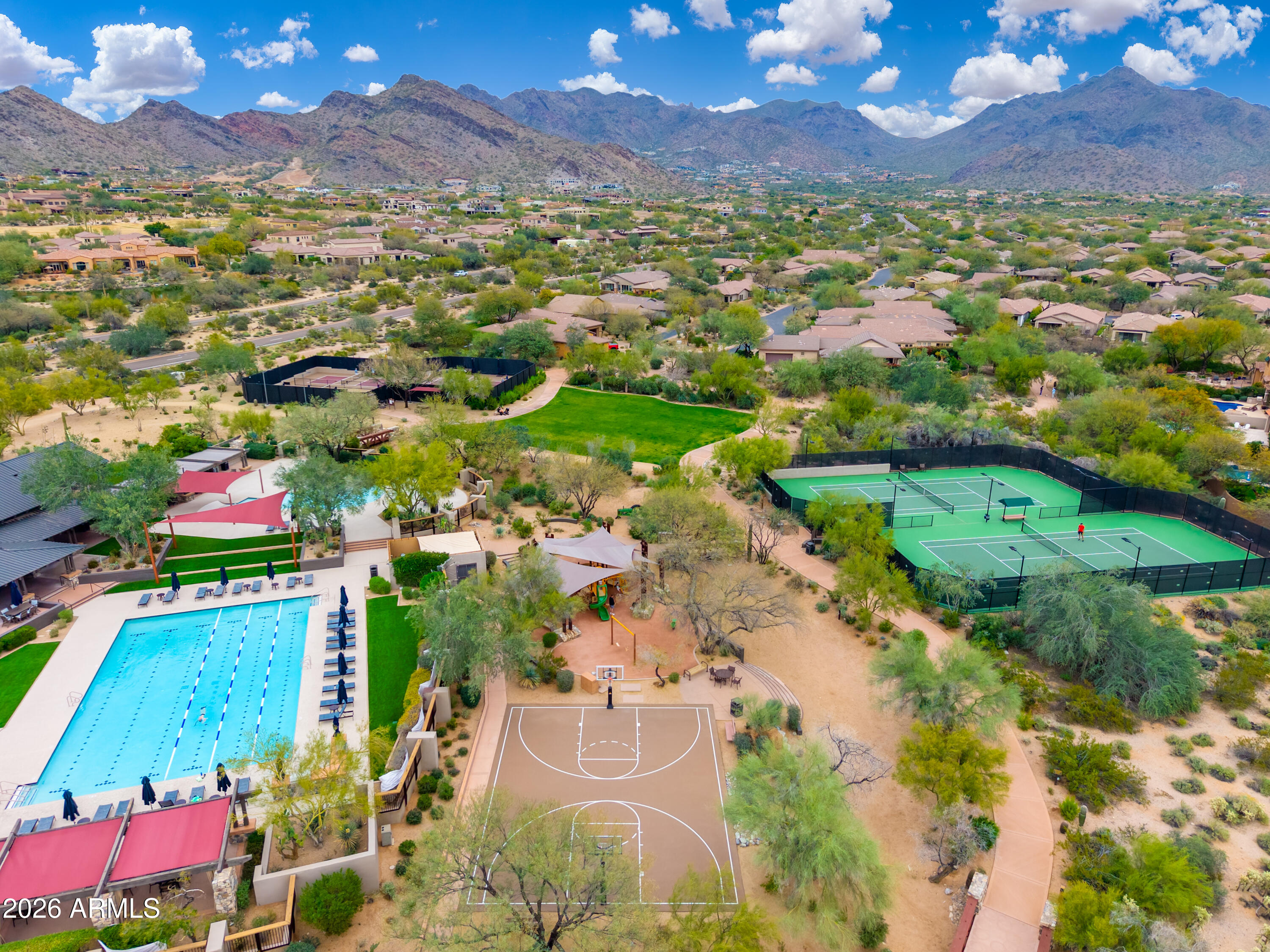Community recreation area with a pool, tennis courts, basketball court, and mountain views.