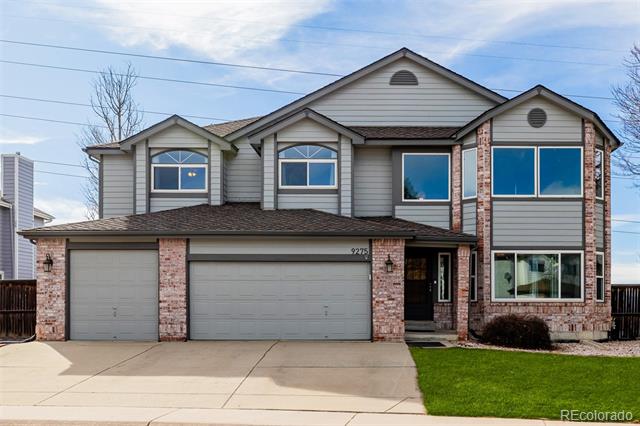 Two-story gray house with brick accents, a double garage, and a green front lawn.