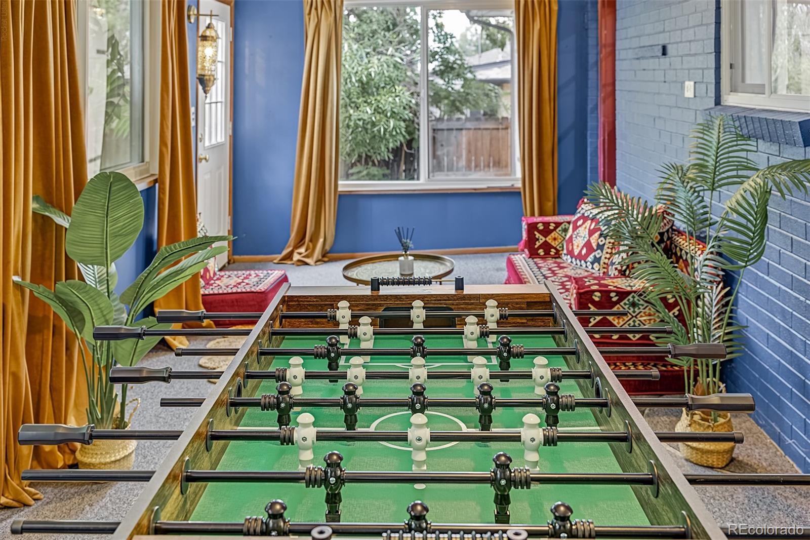 Game room with foosball table, patterned seating, and blue walls.