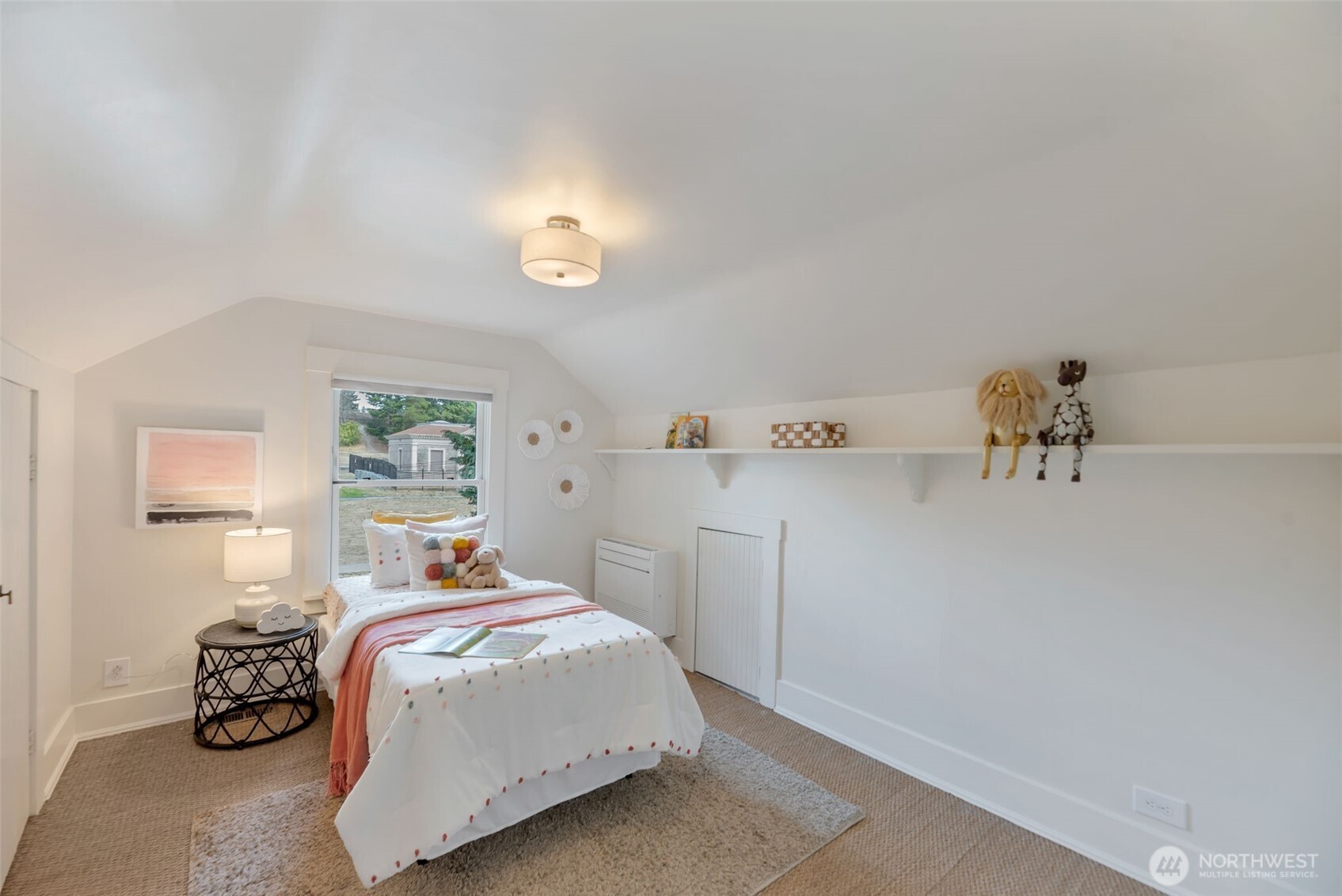 Furnished bedroom with a sloped ceiling, a single bed, plush toys, and a long wall shelf.