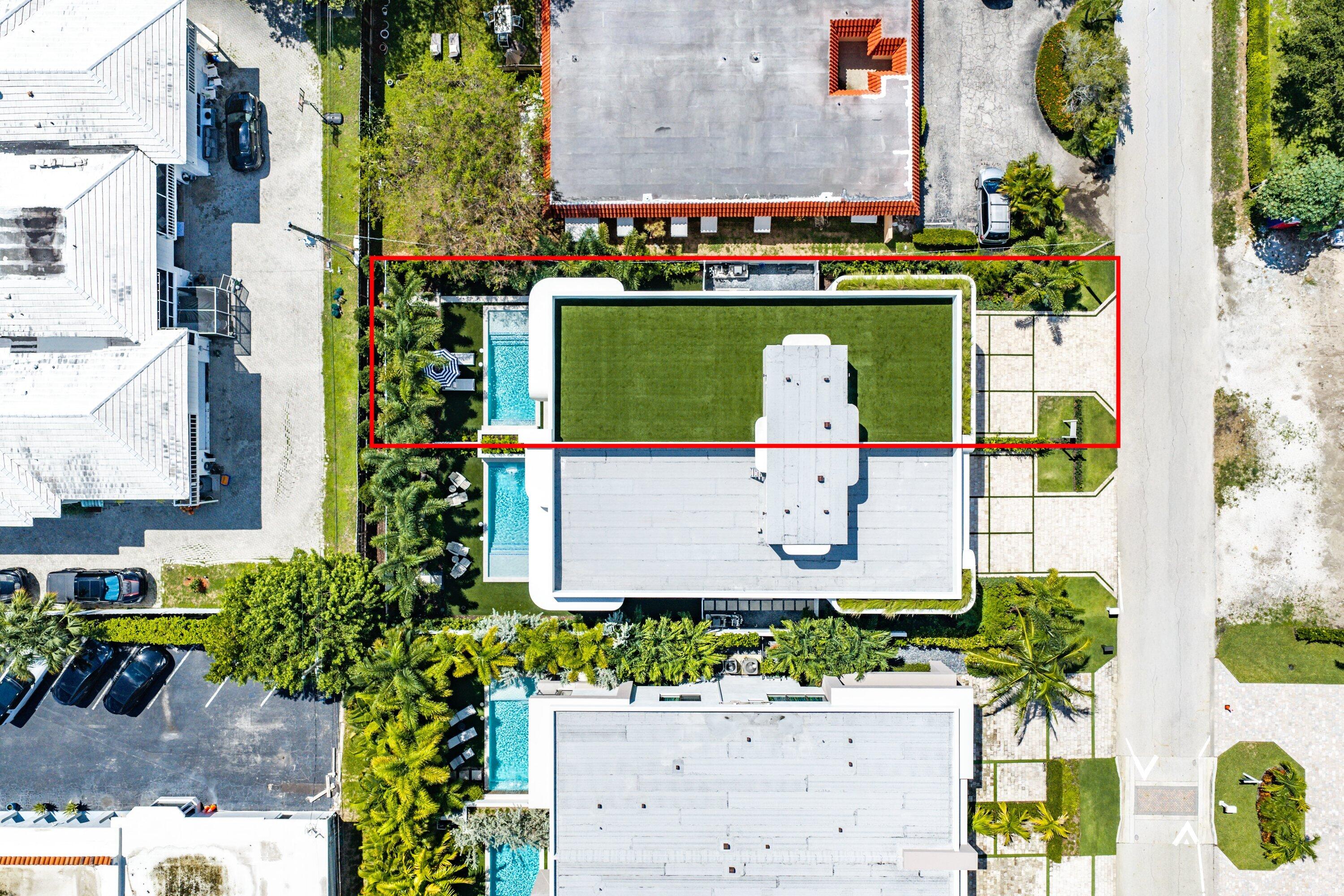 Aerial view of a modern home with rooftop lawn, swimming pools, and a red boundary outline.