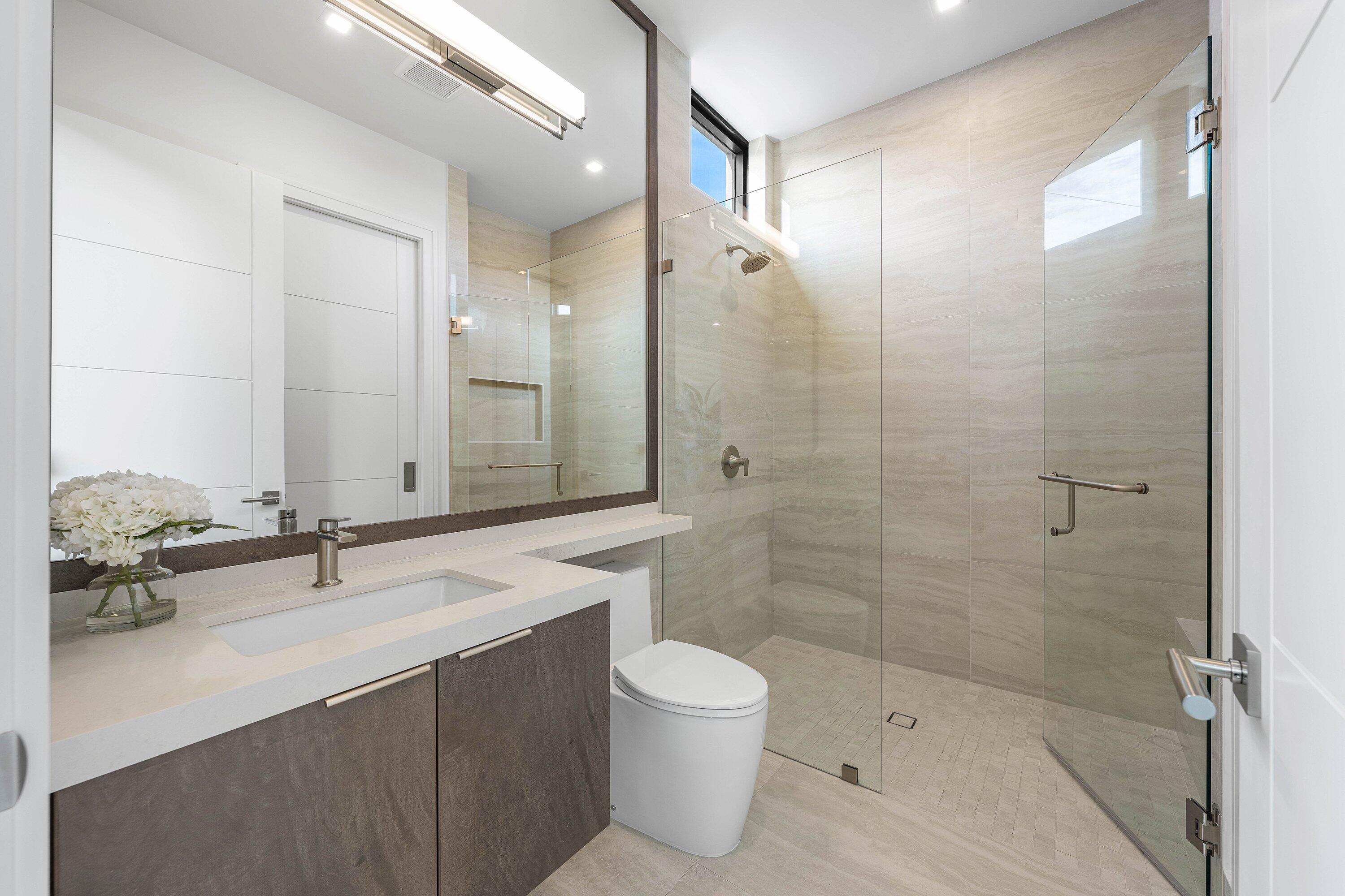 Modern bathroom with a floating vanity and spacious glass-enclosed shower.