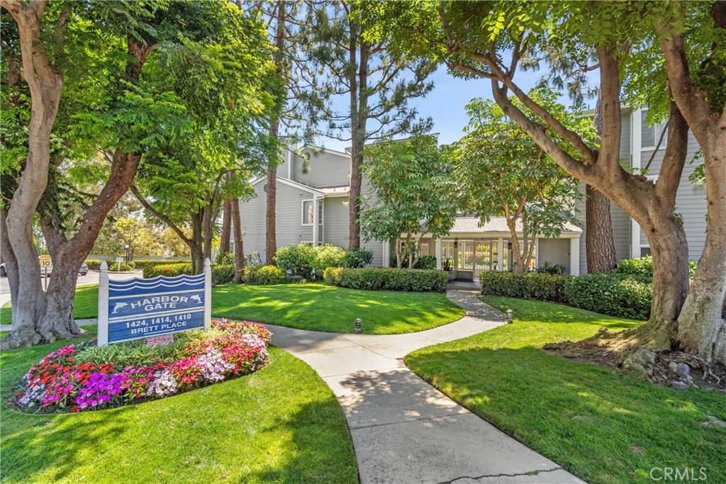 Harbor Gate residential building behind a landscaped lawn, mature trees, and a Brett Place sign.