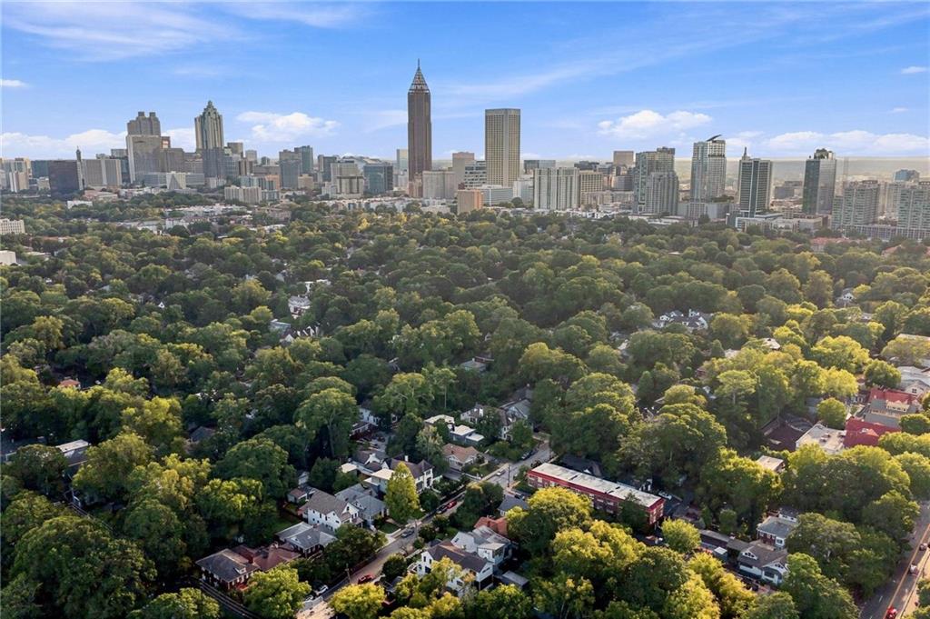 Atlanta skyline rising behind a tree-covered residential neighborhood.