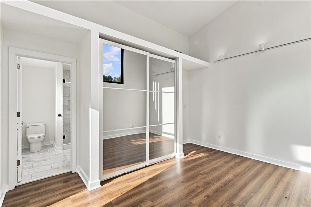 Vacant bedroom with a sliding closet partition and adjoining bathroom doorway.