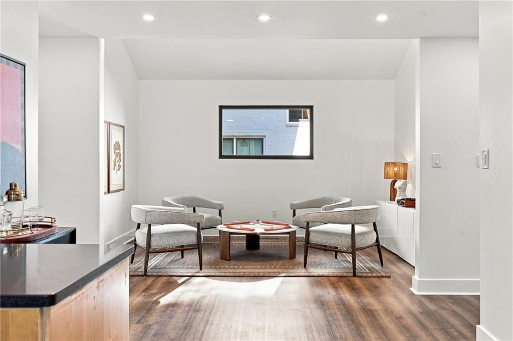 Sitting area with two upholstered armchairs, a low coffee table, and a narrow horizontal window.