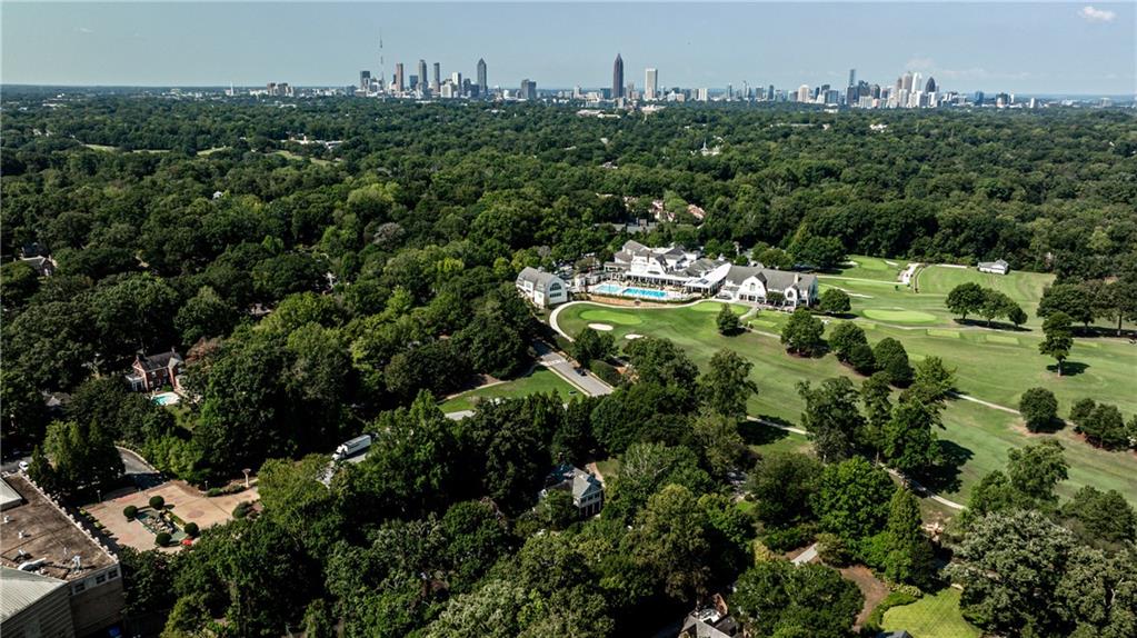 Aerial view of a wooded estate and golf course with the Atlanta skyline beyond.