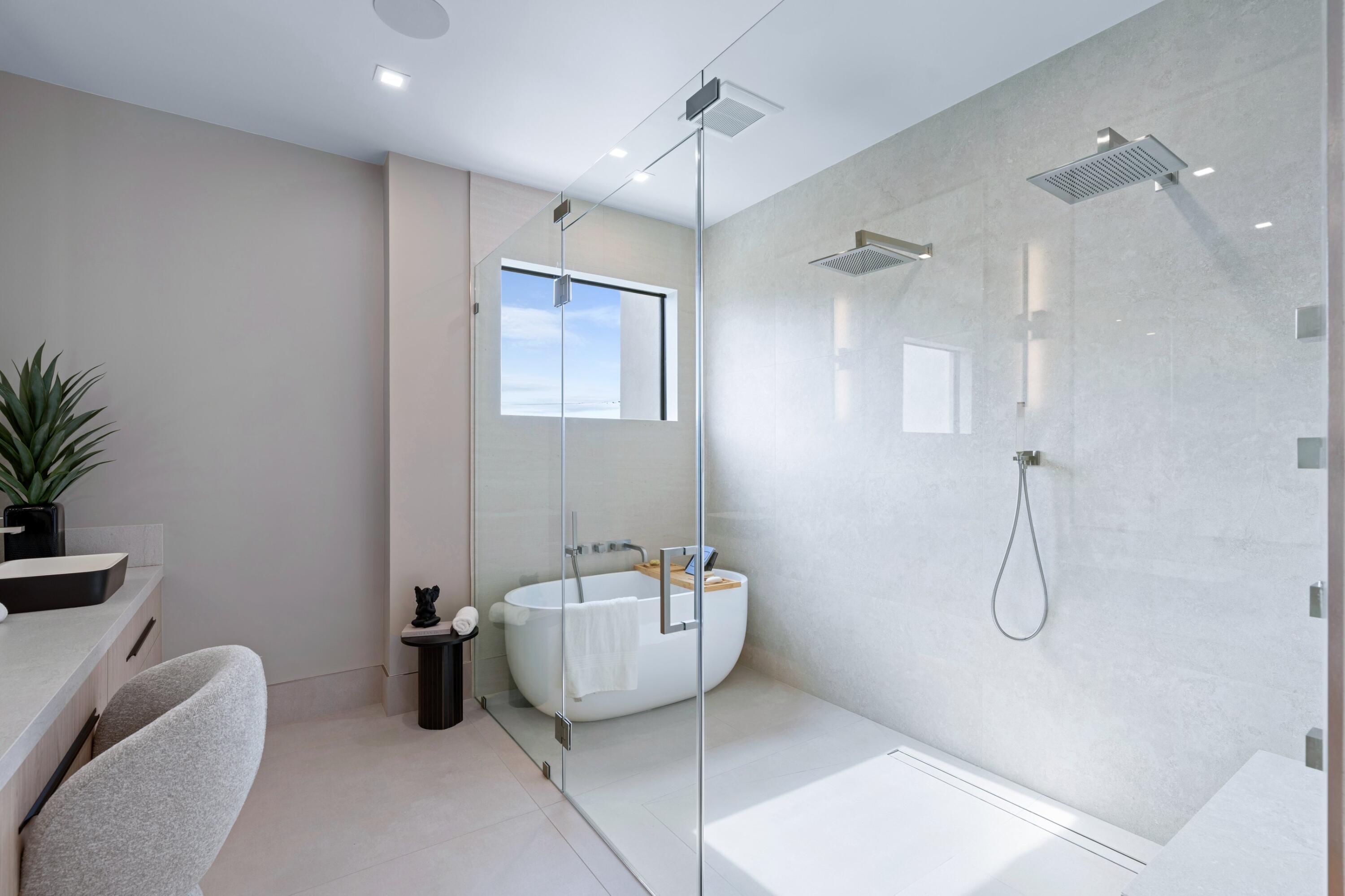Modern bathroom with a freestanding tub and glass-enclosed dual shower.