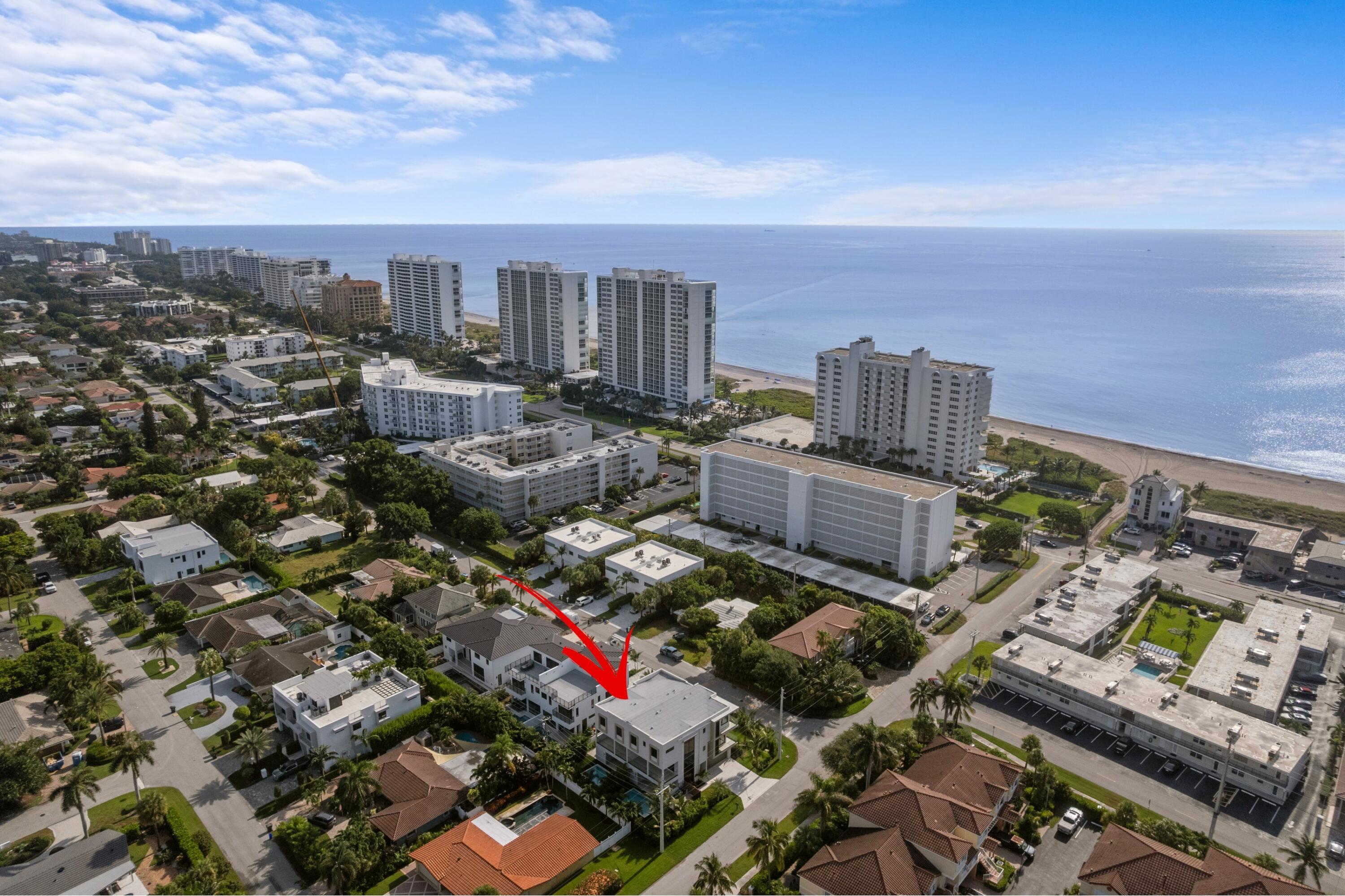 Aerial view of 3099 Banyan Road B, marked by a red arrow, with the ocean and beachfront towers beyond.