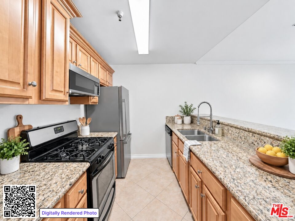 Kitchen with wood cabinets, speckled counters, stainless appliances, and a double-basin sink.