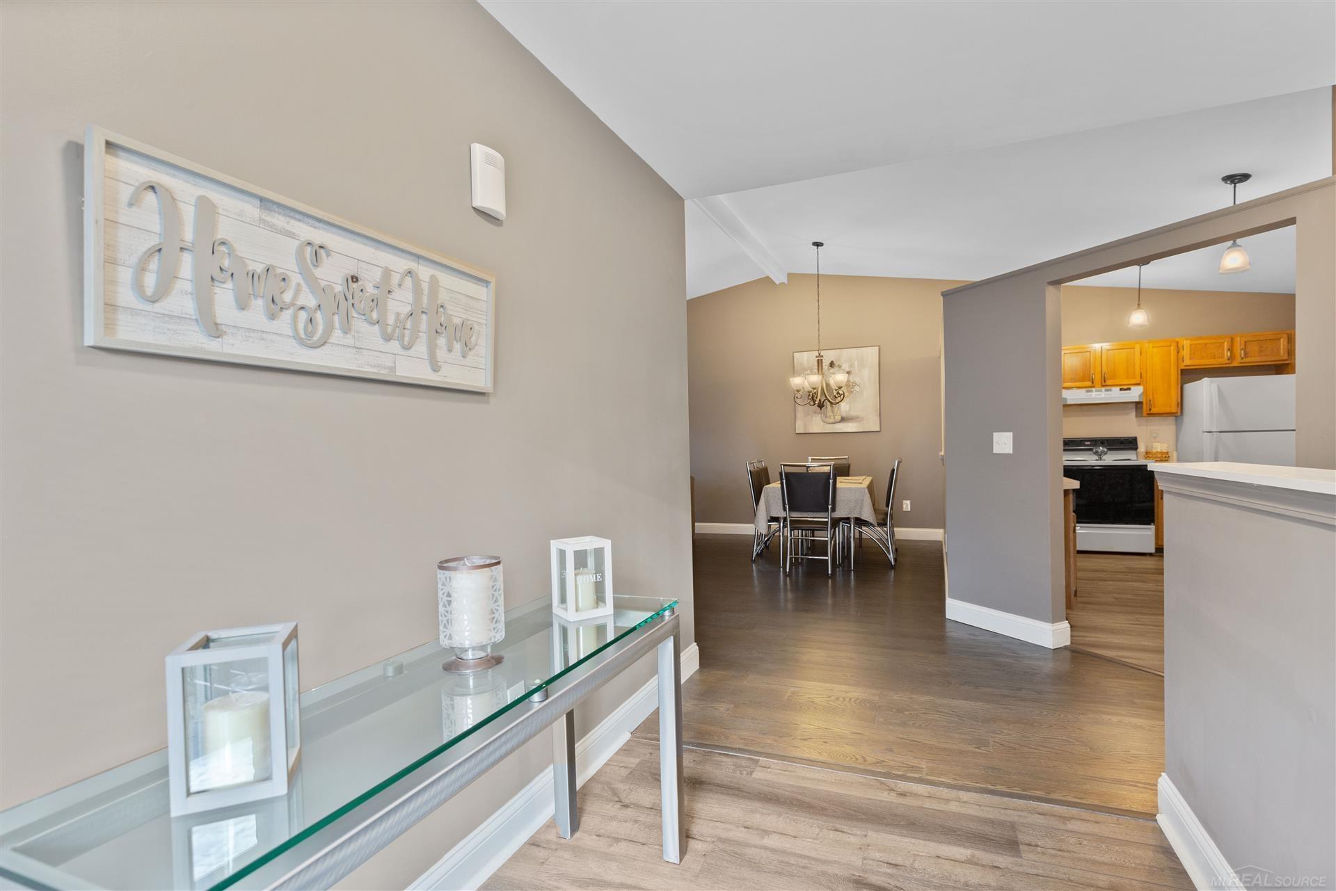 Entryway with a glass console table opening onto a dining area and kitchen.