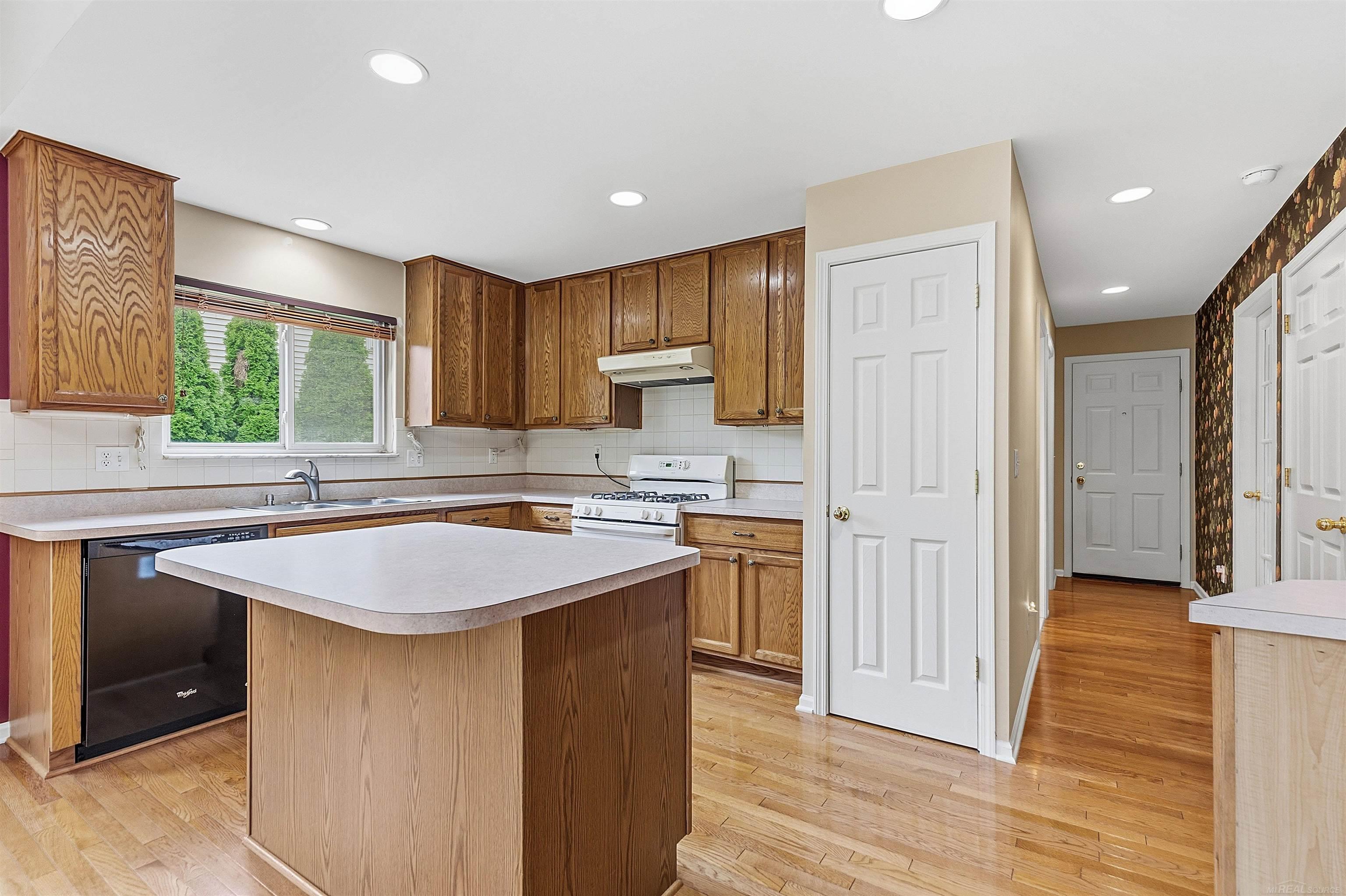 Kitchen with oak cabinets, a central peninsula, and hardwood floors.