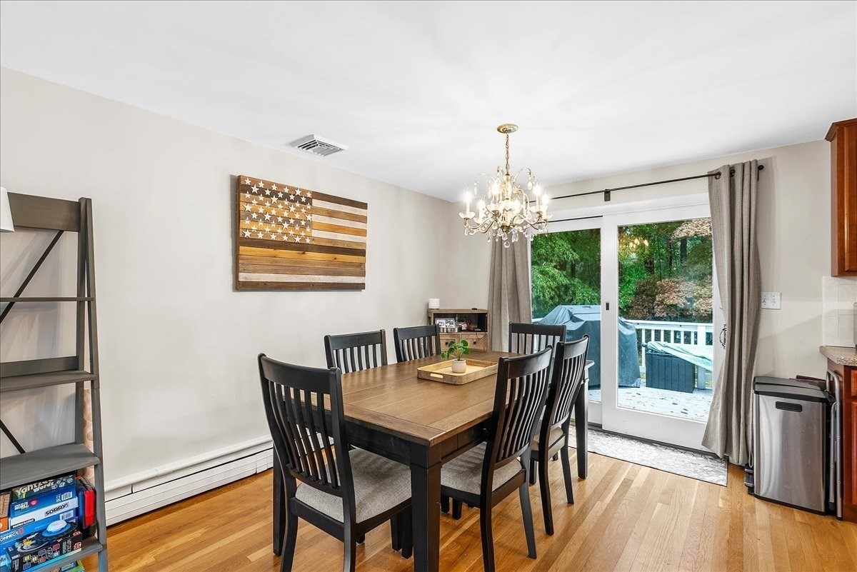 Dining room with a wooden table, black chairs, and sliding glass doors to a deck.
