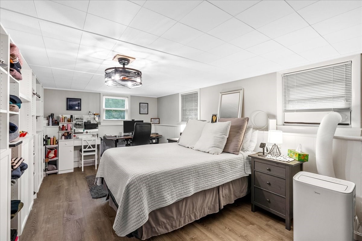 Bedroom with a large bed, built-in shelving, and a desk and vanity area.