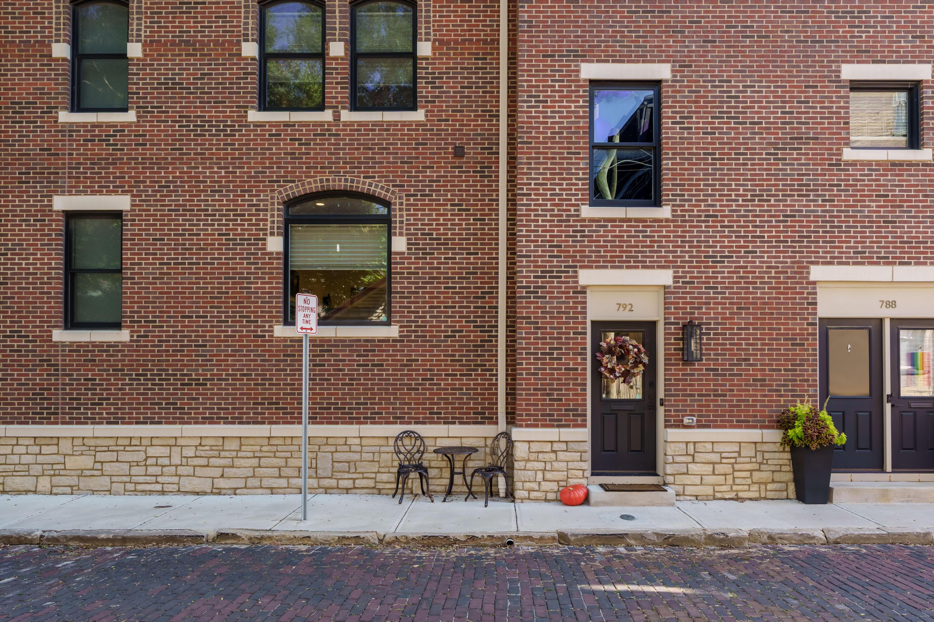 Red-brick townhouse at 792 Highland Street with a wreath on the entry door and a small pumpkin by the steps.