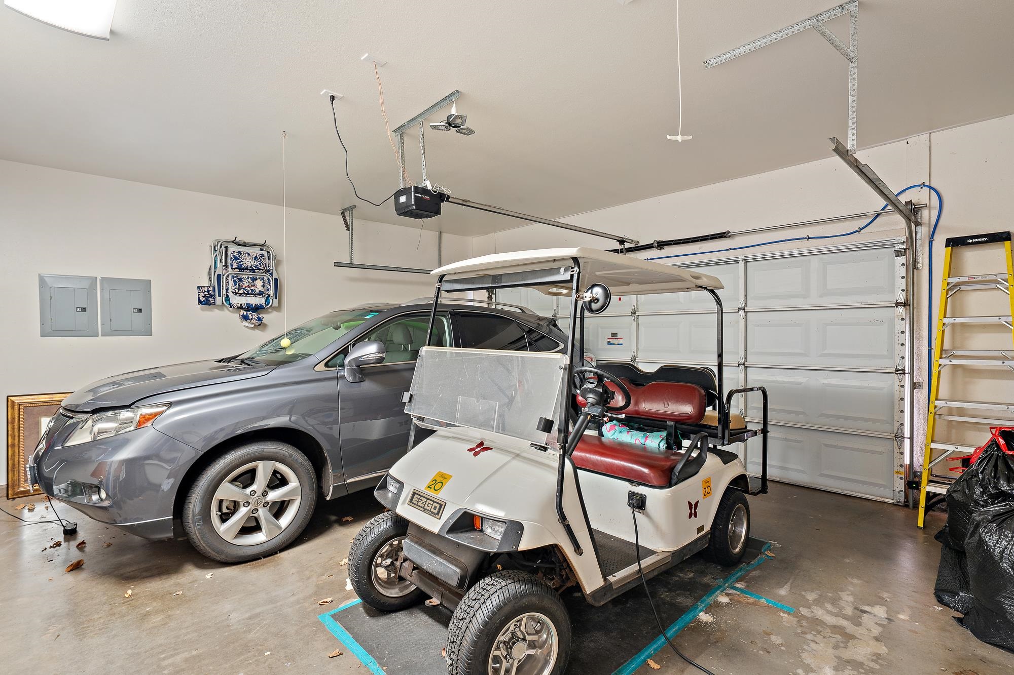 Garage with a gray SUV and white golf cart parked beside the closed garage door.