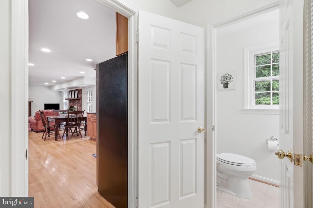 Bathroom with a toilet and window, viewed through a doorway beside an adjoining dining area.
