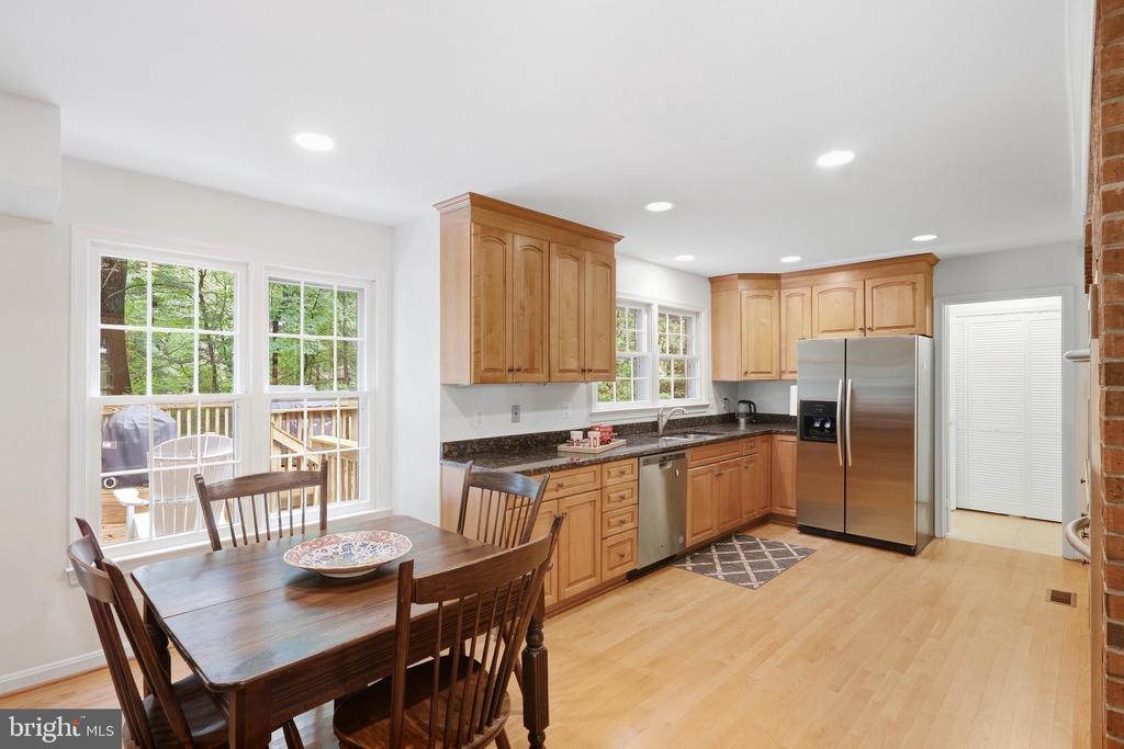 Kitchen and dining area with wood cabinets, stainless appliances, and windows overlooking a deck.