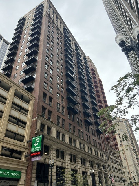 Downtown Chicago high-rise with rows of balconies viewed from below on a cloudy day.
