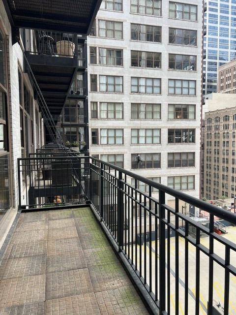 Balcony with black metal railings and views of neighboring downtown buildings.