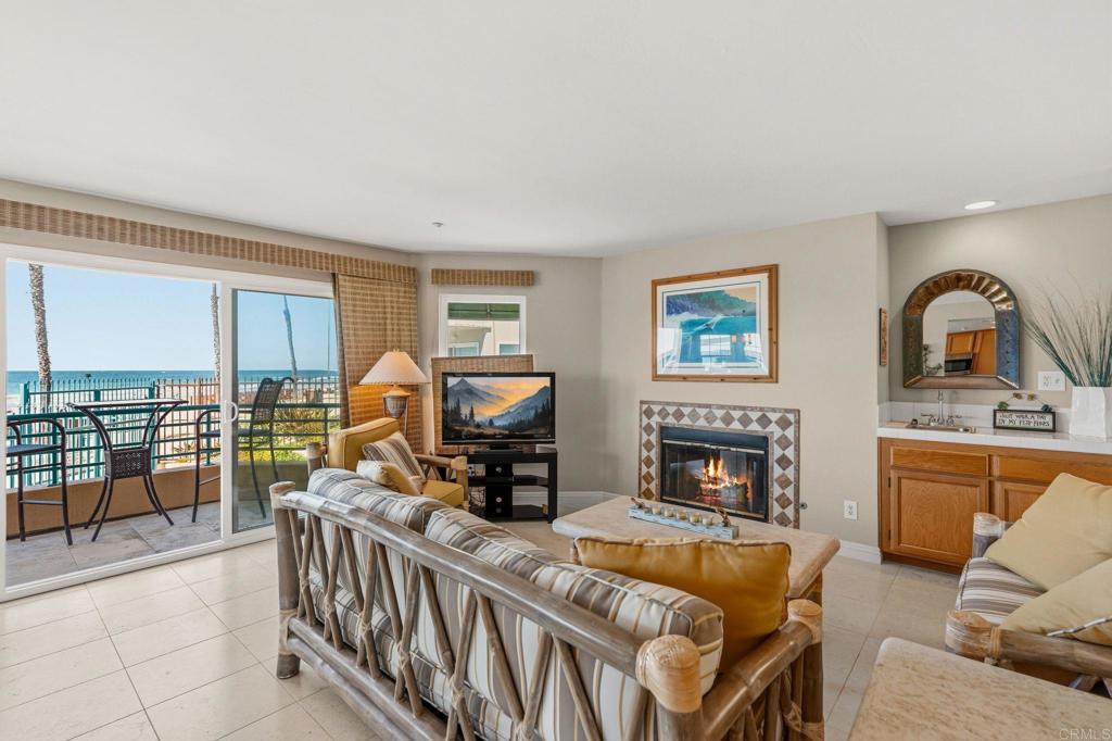 Living room with a fireplace and ocean views through sliding glass doors.
