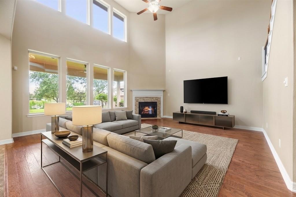 Living room with a vaulted ceiling, tall windows, and a fireplace.
