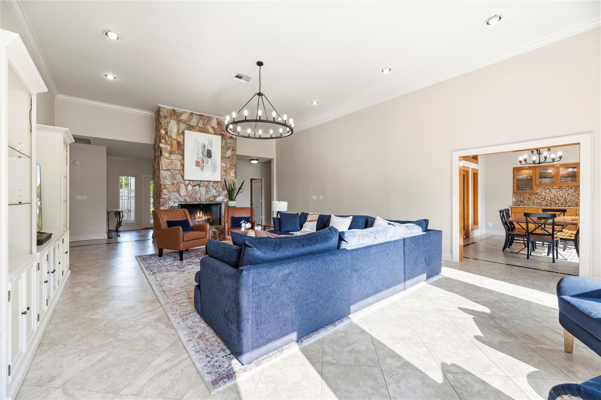 Living room with a blue sectional, stone fireplace, and adjoining dining area.