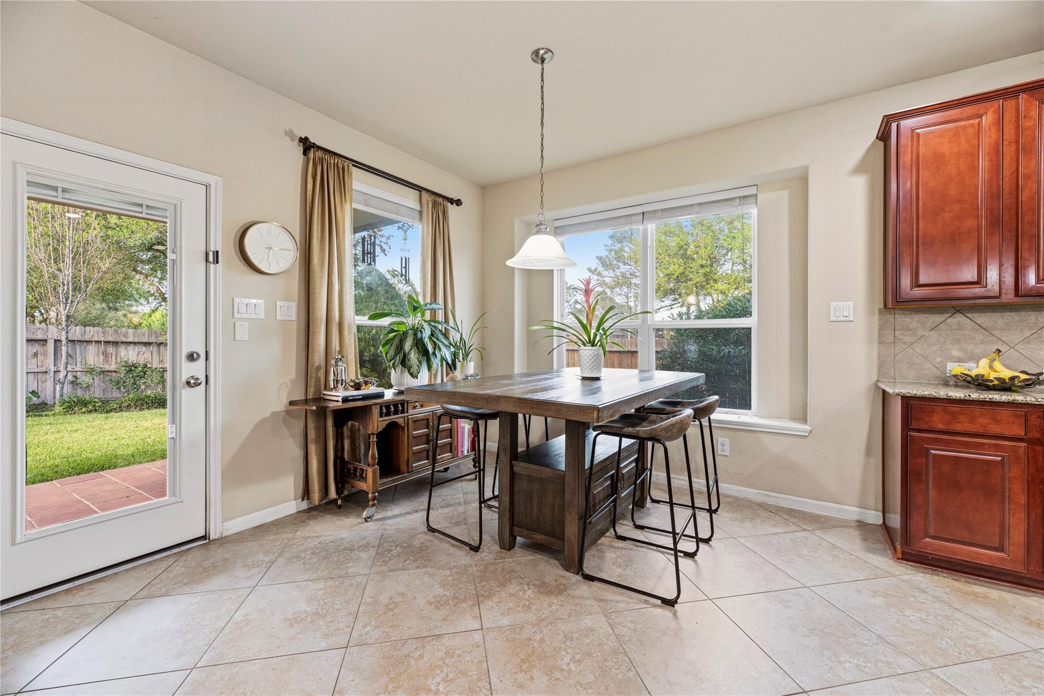Breakfast nook with a dark wood table beside large windows and a glass door to the backyard.