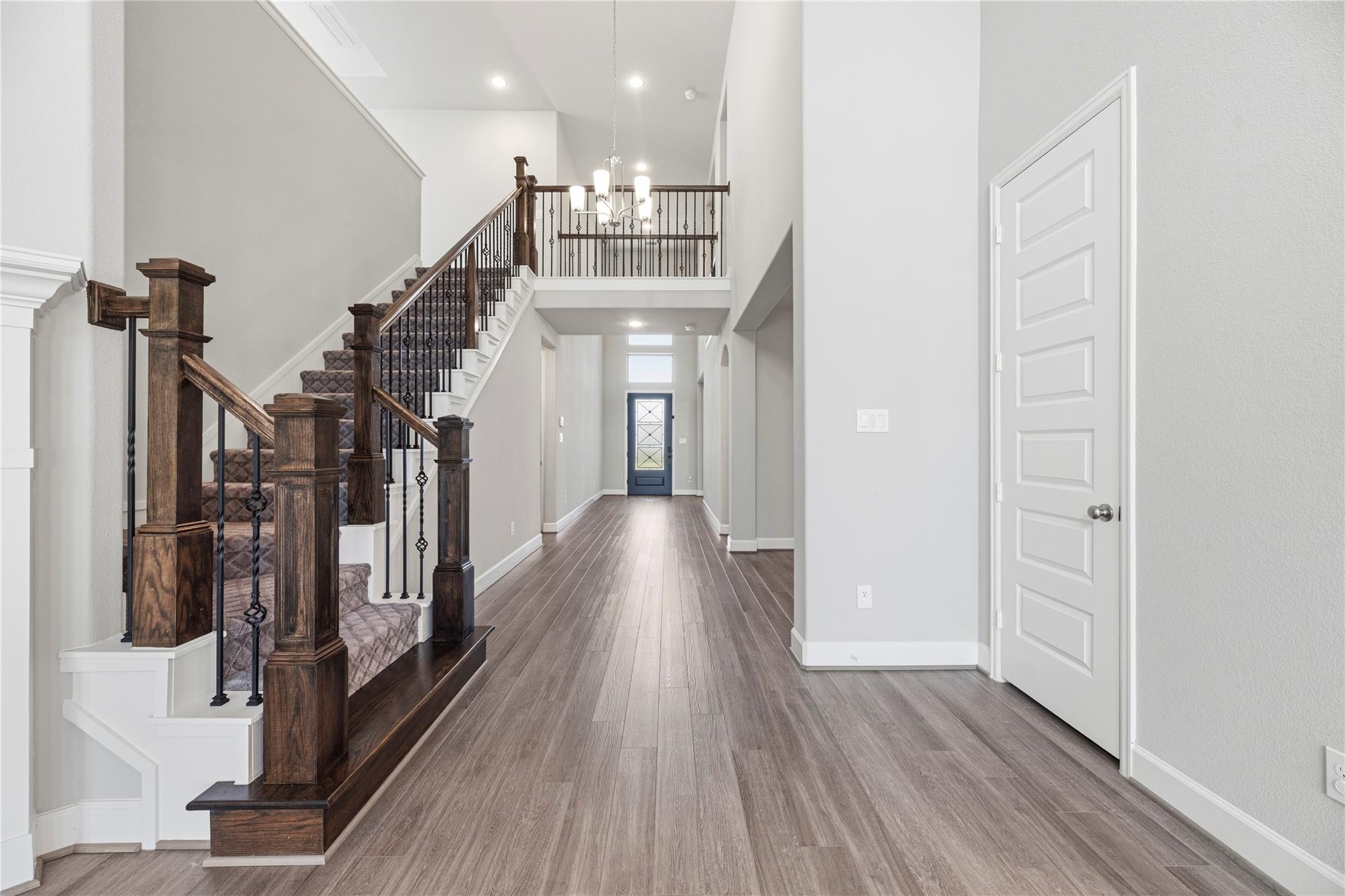 Two-story entry foyer with a dark wood staircase and patterned carpet.