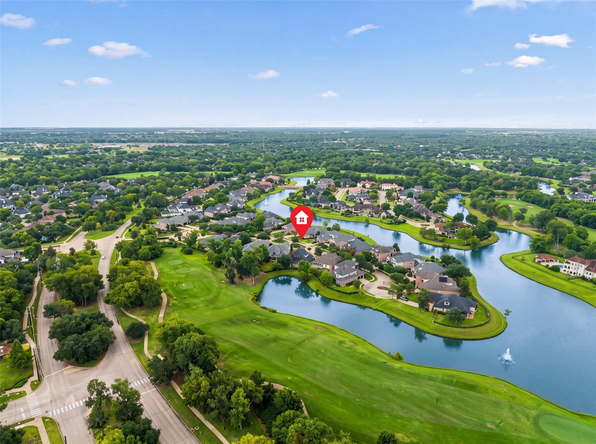 Aerial neighborhood view with a golf course, winding waterways, and a red marker at the listed home.