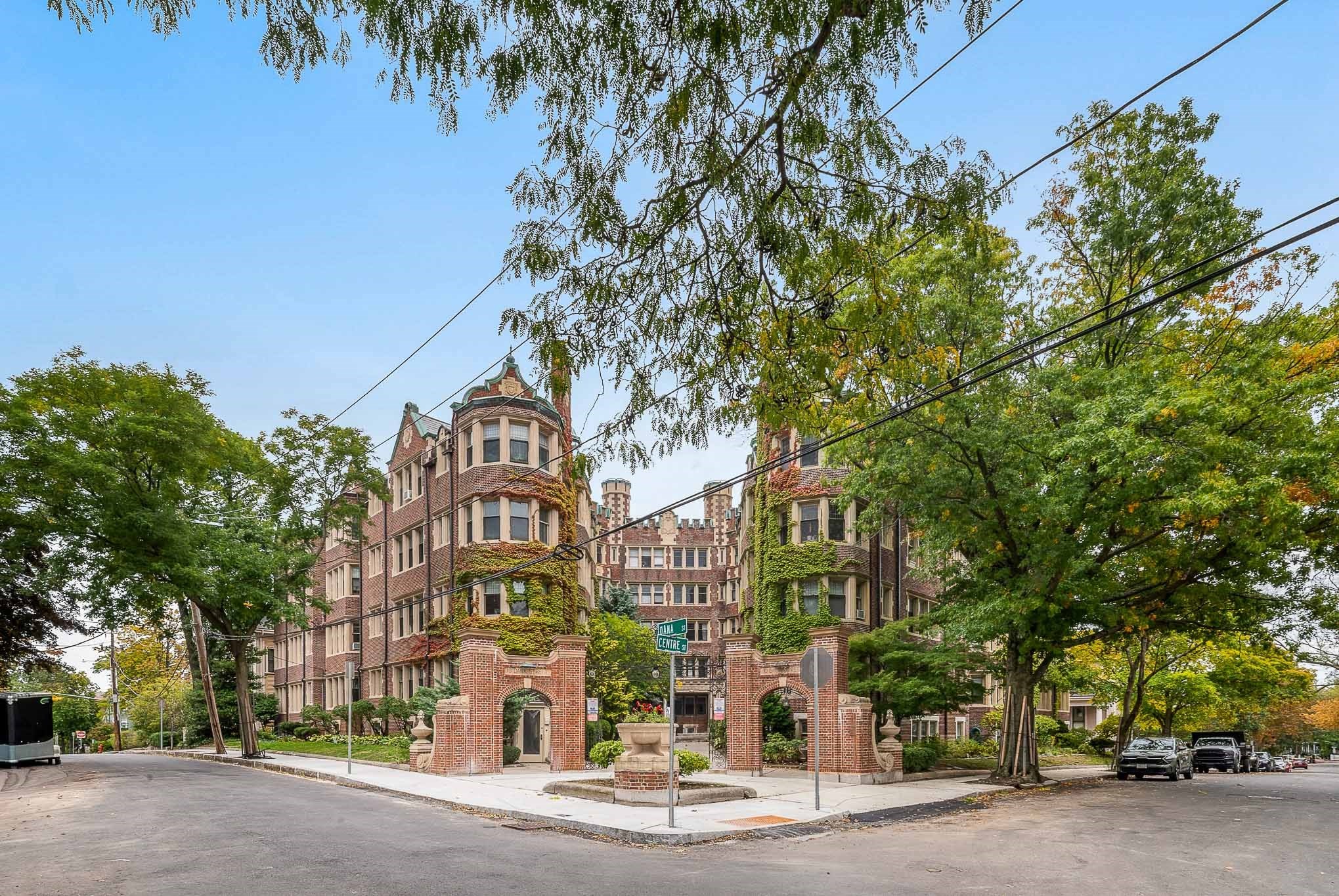 Ivy-covered brick apartment building with ornate entrance gates at Dana and Centre streets.