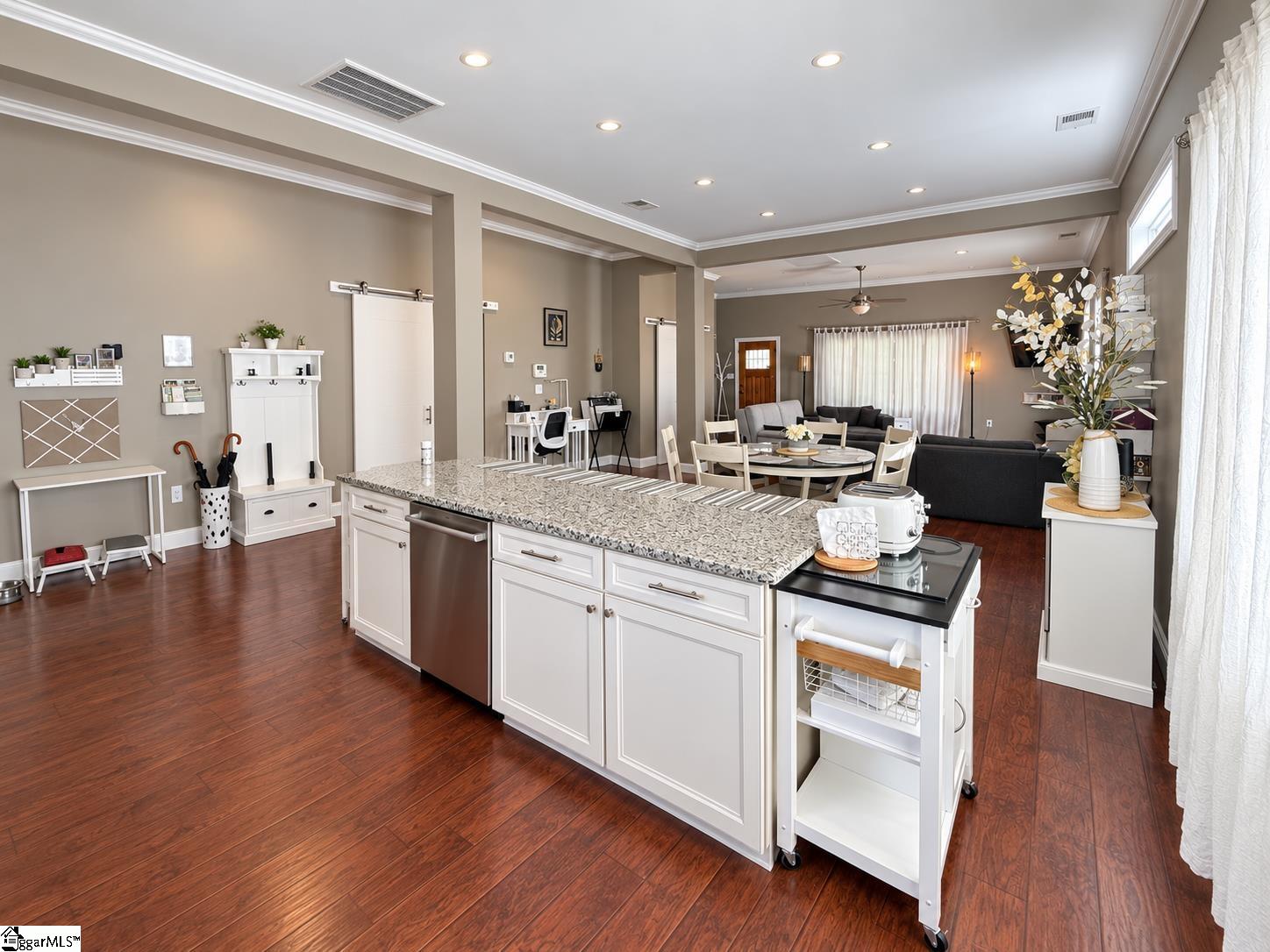 Open-plan kitchen with a granite-topped island overlooking the dining and living areas.