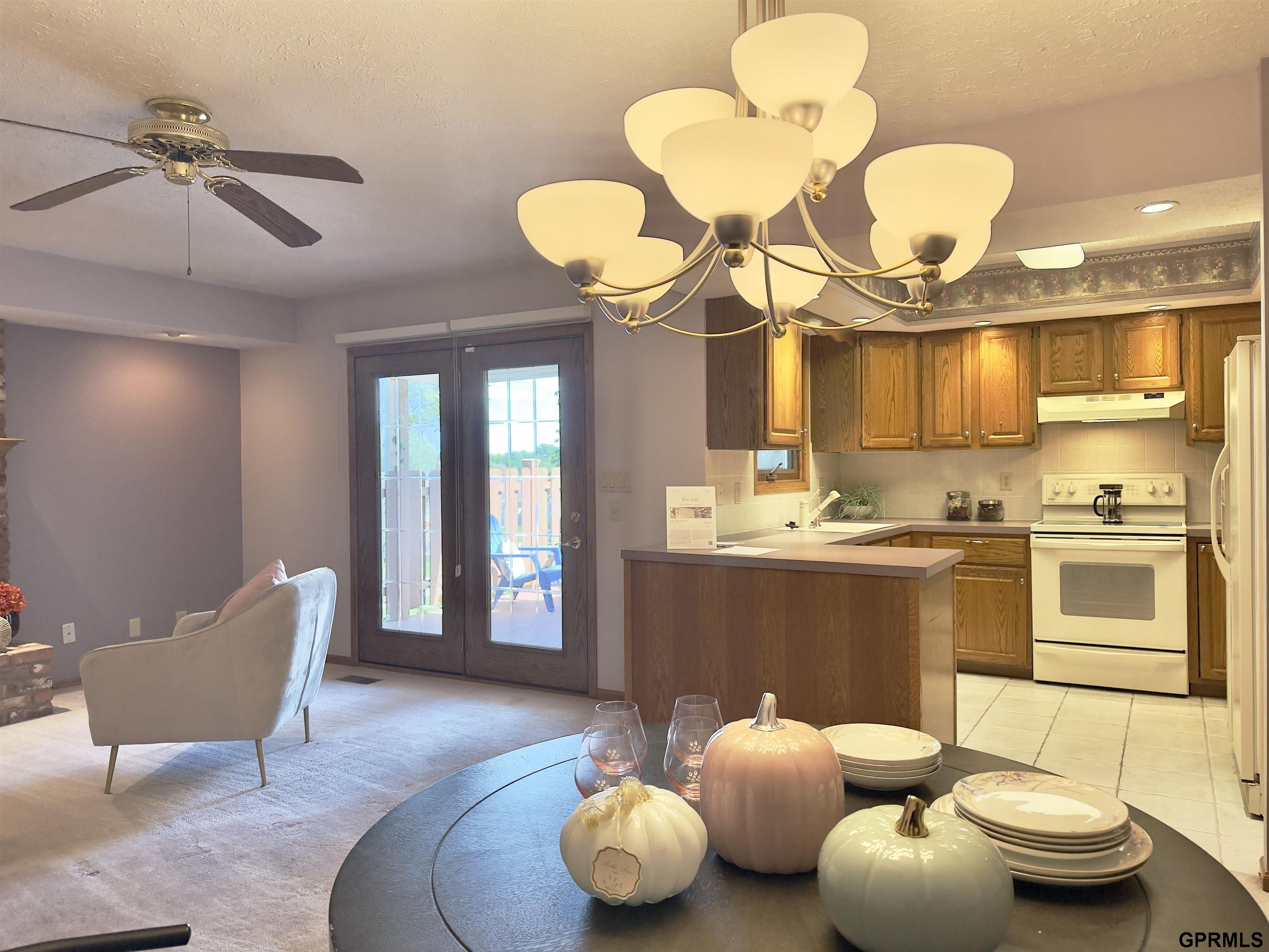 Open-plan dining area and kitchen with wood cabinets, a central island, and glass doors to a deck.
