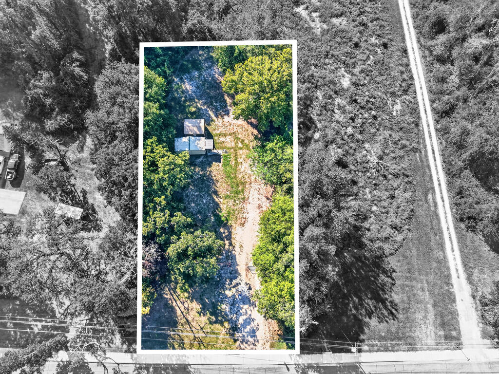 Wooded property outlined in white, with a small structure and cleared path through the lot.