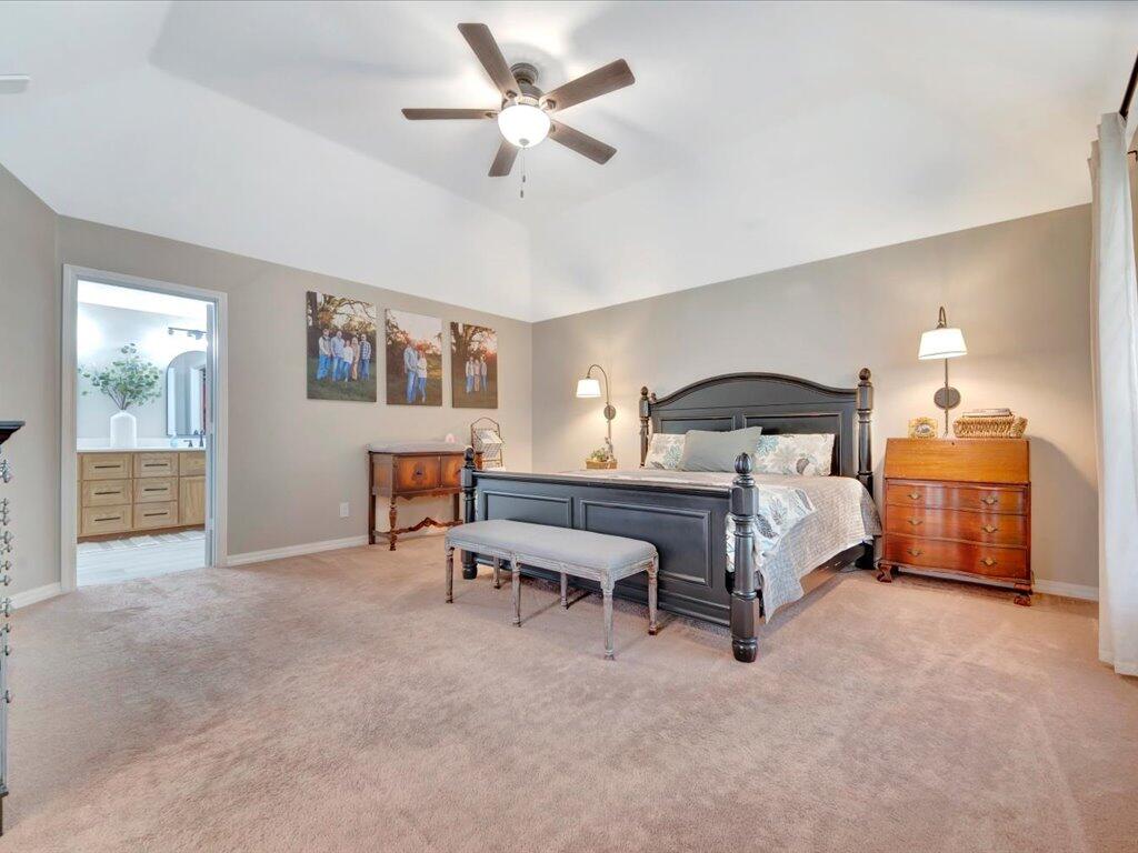 Furnished bedroom with a dark wood bed, matching dressers, and a bench at the foot.