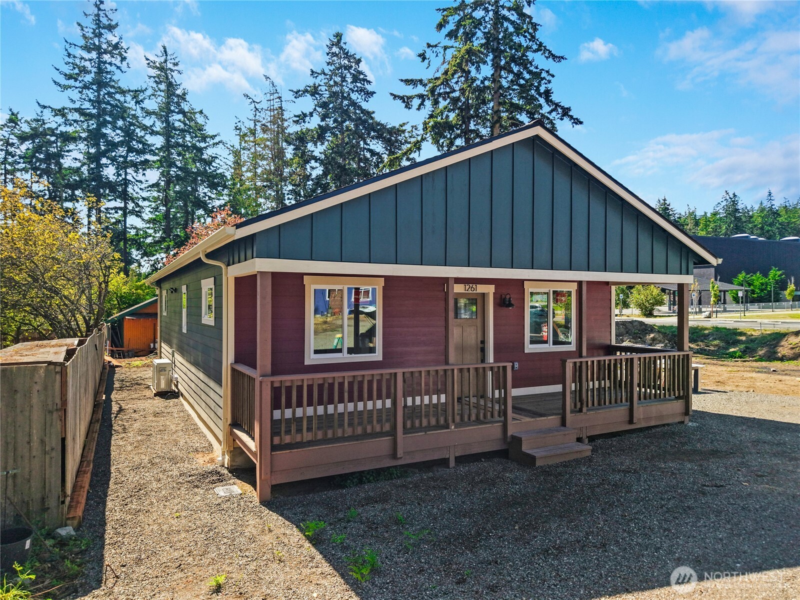 Single-story burgundy house with a dark gabled facade and covered wooden porch.