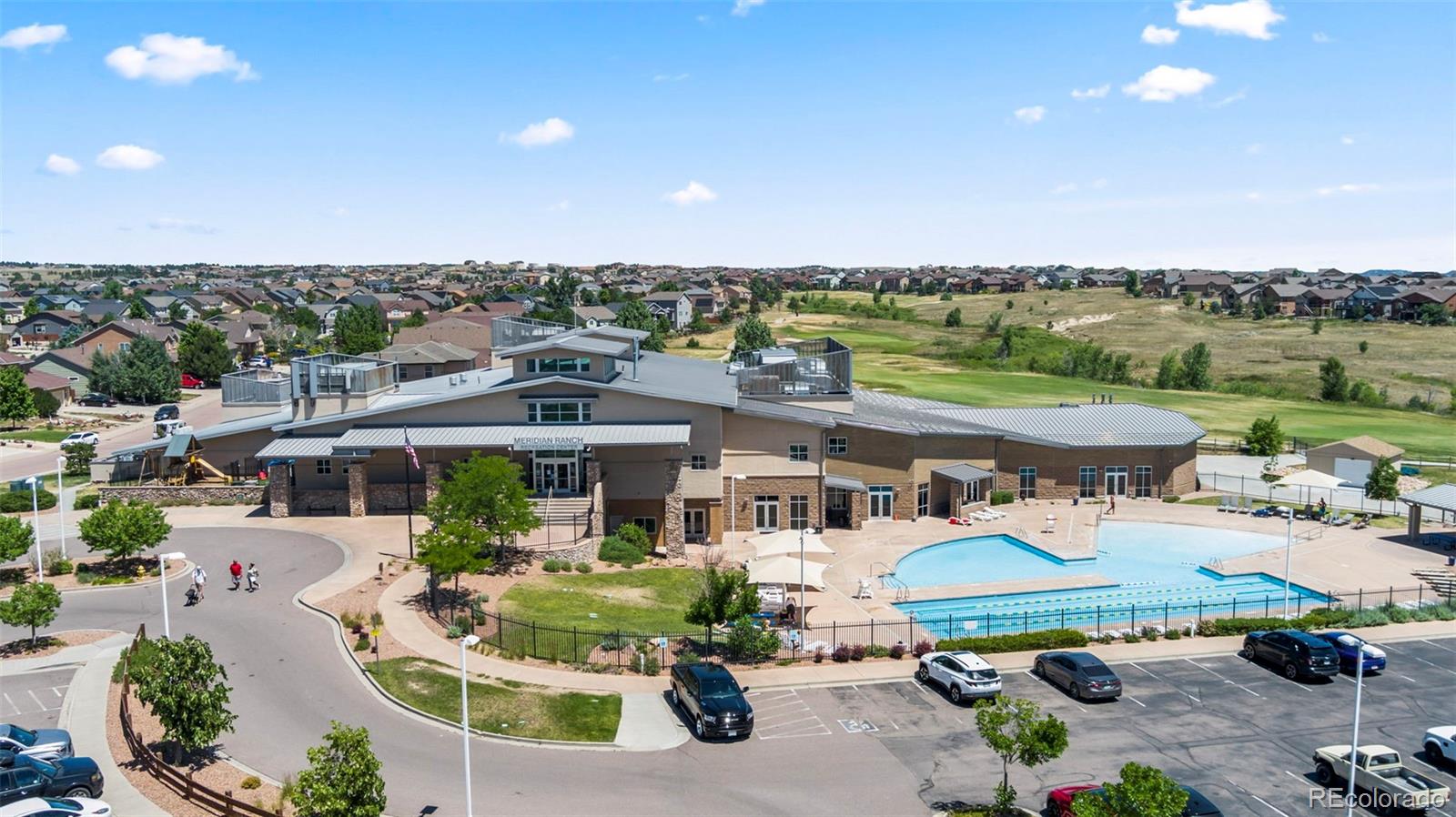 Aerial view of Meridian Ranch clubhouse and outdoor swimming pool surrounded by homes.