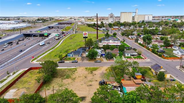 Aerial view of a vacant lot beside a highway and industrial buildings.