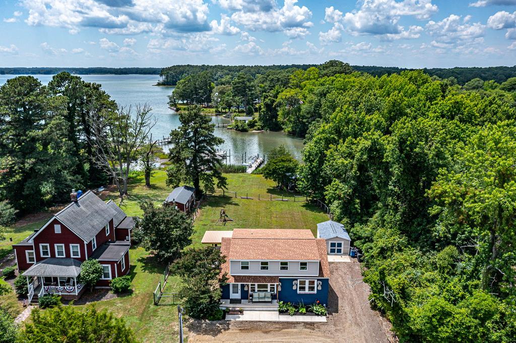 Waterfront homes and private dock beside a broad waterway, viewed from above.