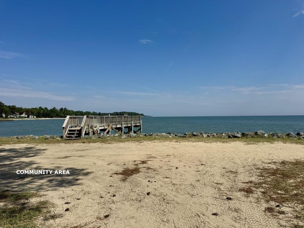 Community beach with a wooden pier extending over the water.