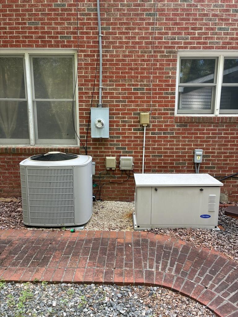 Brick house exterior with two HVAC units beside a curved brick patio.